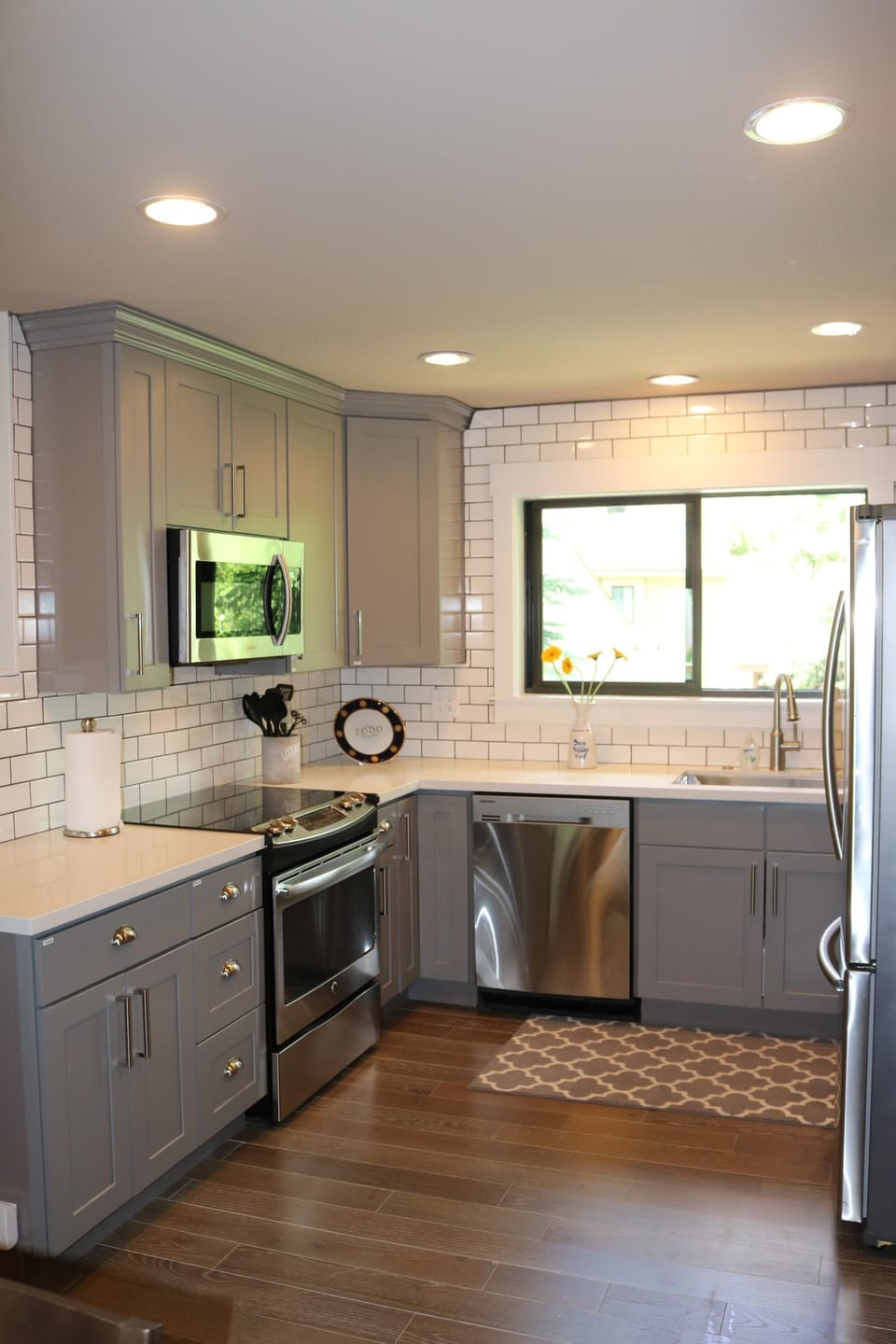 All new: subway tiles, gray cabinets, white quartz counter tops, hardwood floors