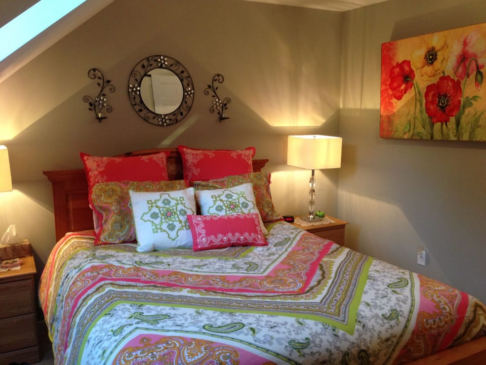 Bedroom with decorations. Another HD TV faces the bed on one of two dressers.