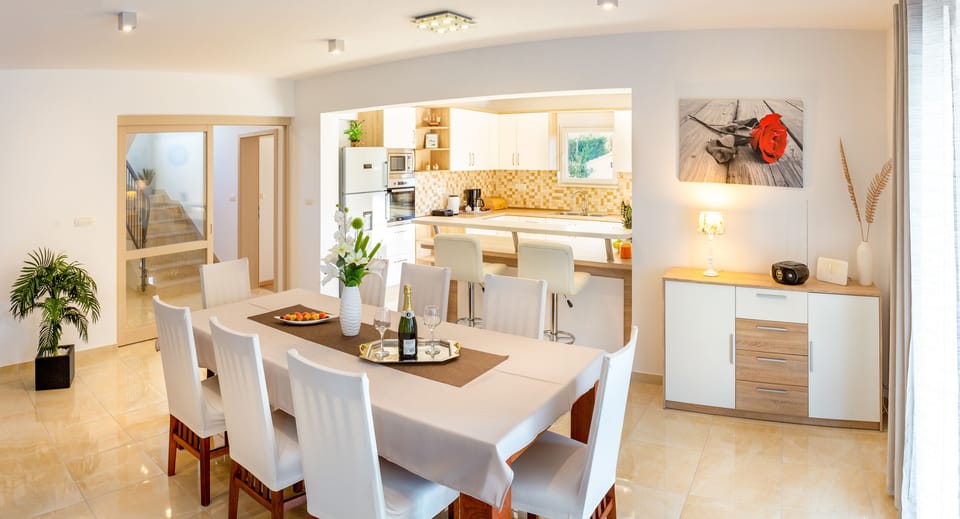 Spacious dining area with large wooden table and chairs for 8 people. 
