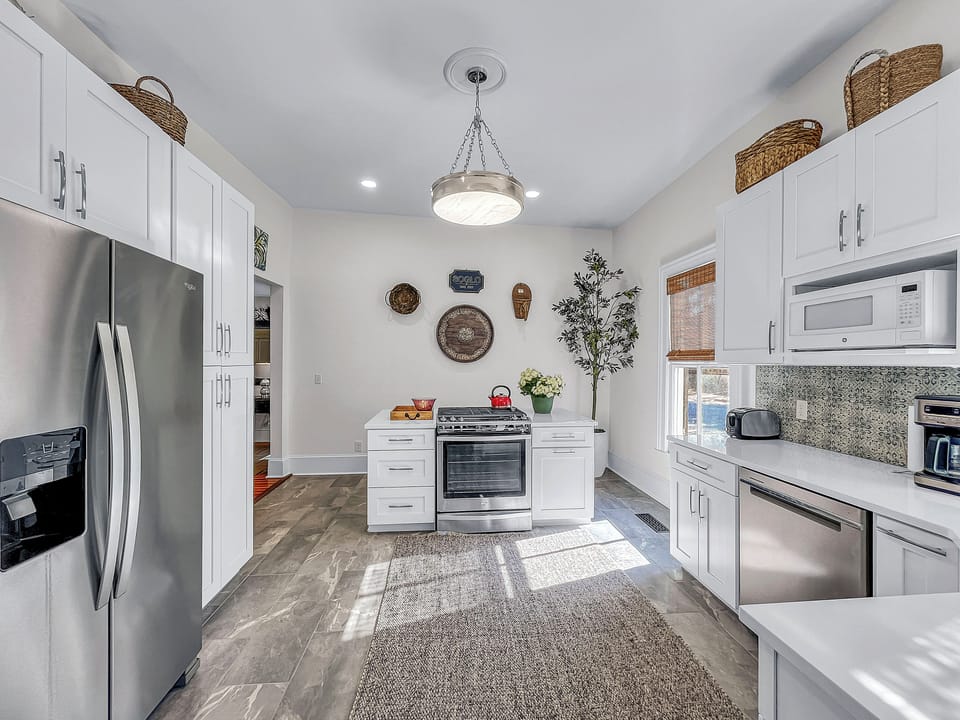 Chef’s kitchen with gas stove and full complement of cooking/serving ware.