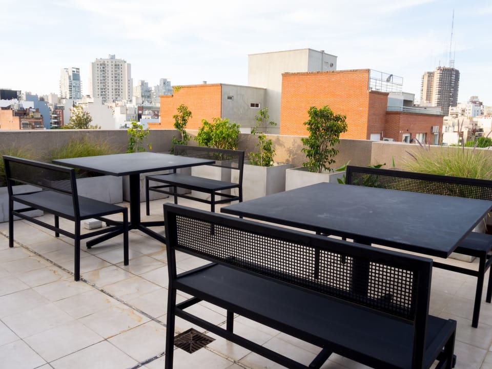 Dine outside with rooftops and taller city buildings spread across the horizon.