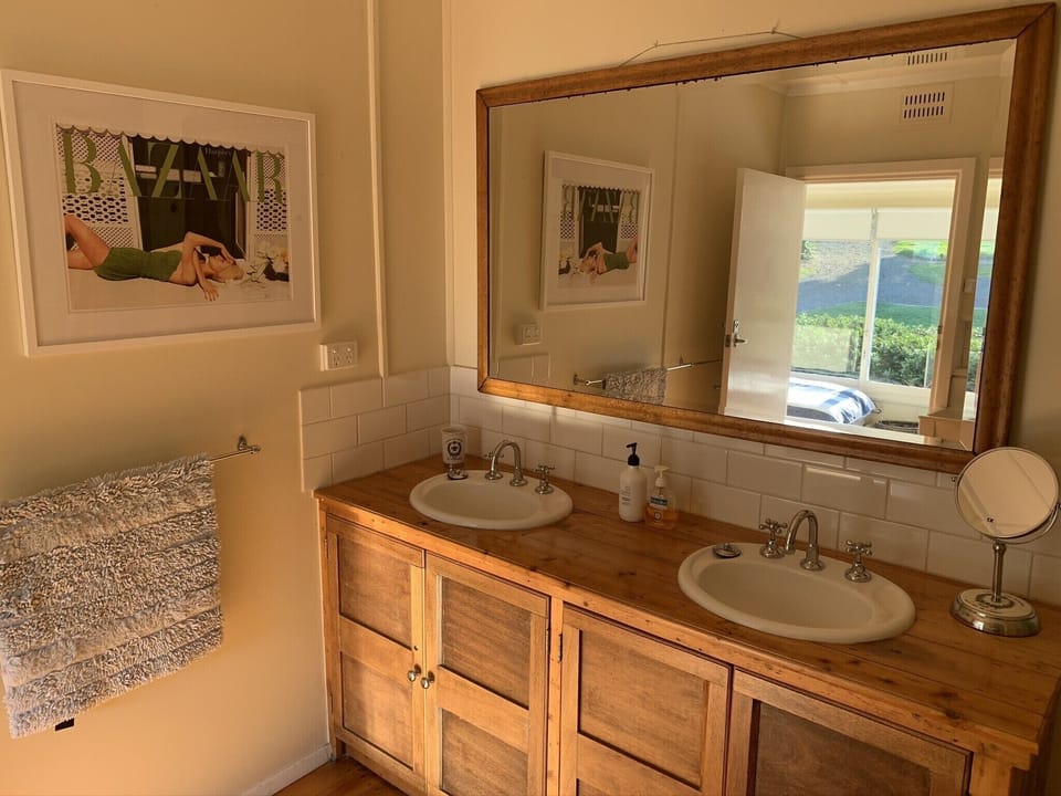Bathroom with large mirror, dual basins, shower and bath.