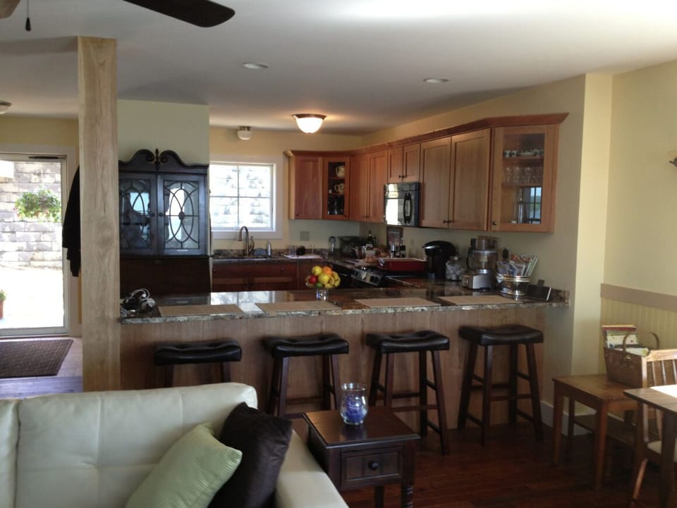 Kitchen view showing seating around the peninsula with granite countertop.
