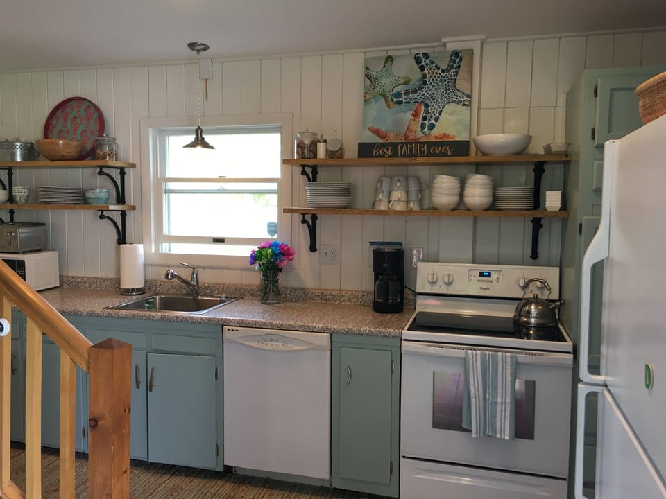 Updated kitchen with new stove, dishes, microwave, and new Weber gas grill.
