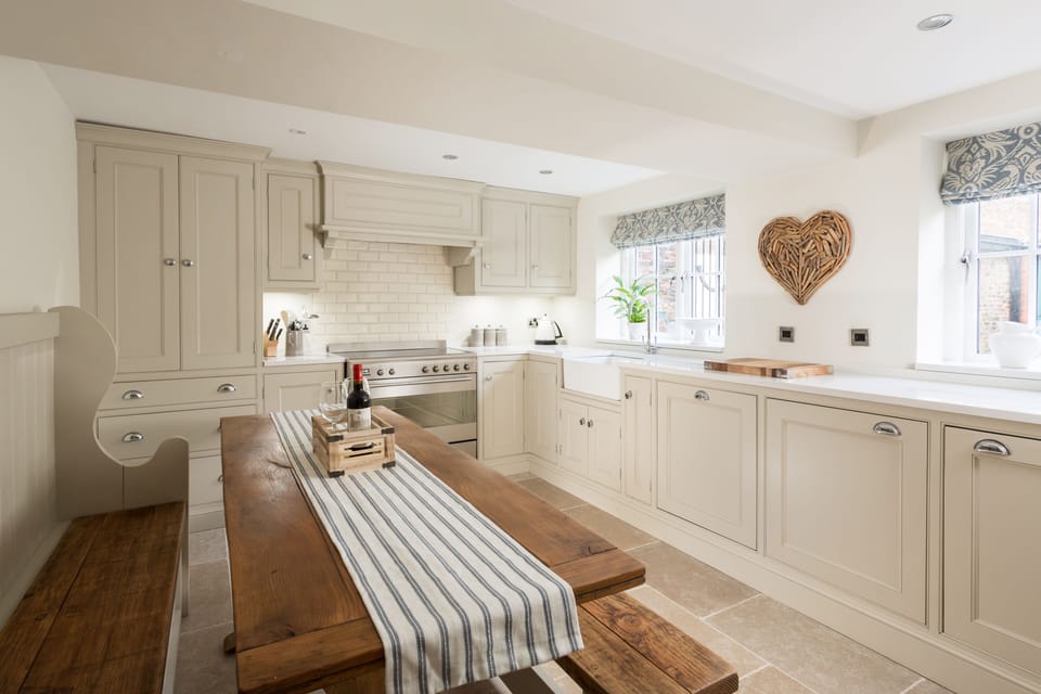 The kitchen showing church pew, antique table and bench, seats 8.