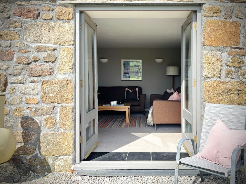 Bright, open-plan living space with comfortable seating and garden access.