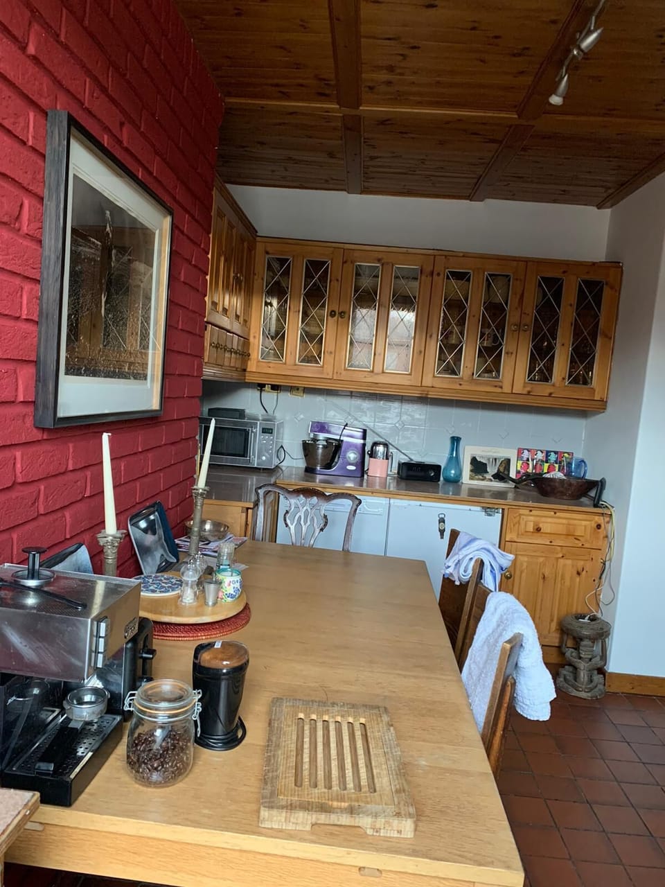 Across table from window is the fridge, freezer, microwave, mixer etc. 