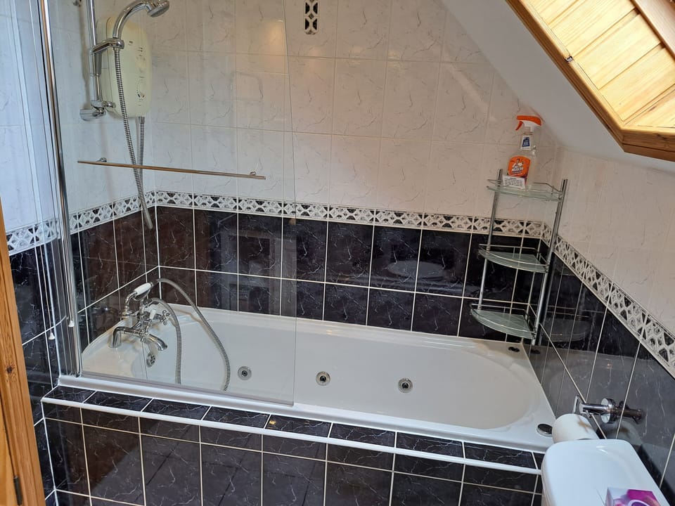 The jacuzzi bath and shower in the upstairs family bathroom