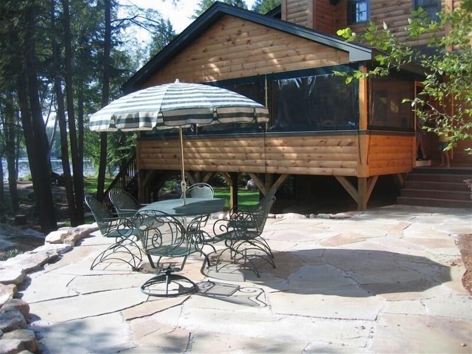 Large patio just off of screened-in porch with table for 6, and big skies