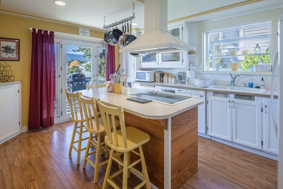 Bright sunny kitchen with island.  Well stocked to cook great meals.