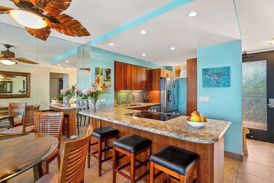 Kitchen features a large granite island, bar stools, and warm wood cabinetry for a functional and inviting space