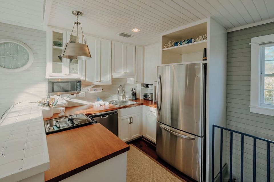 Kitchen area with stove, dishwasher, fridge, microwave, coffee maker & toaster. 