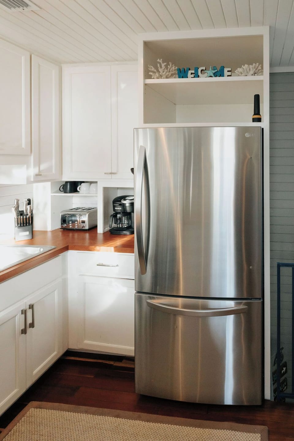 Kitchen area with stove, dishwasher, fridge, microwave, coffee maker & toaster. 