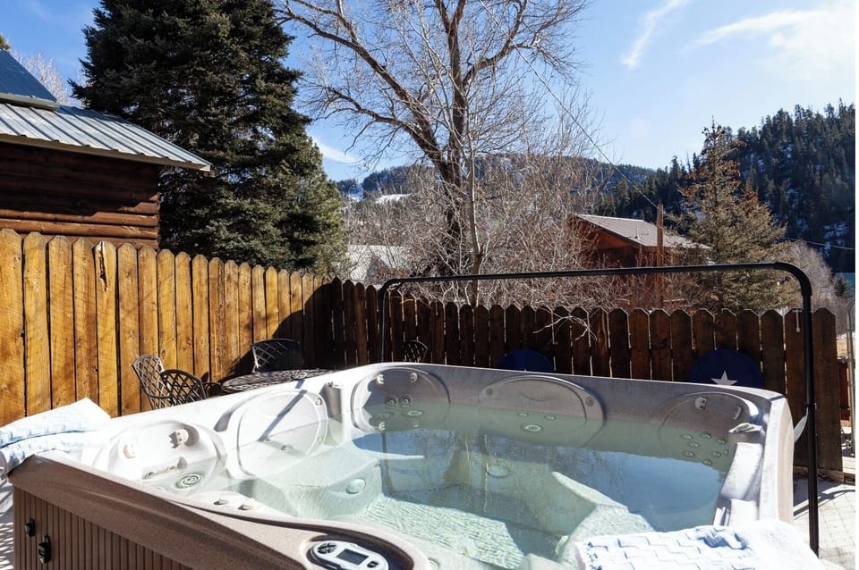 Mountain-view hot tub surrounded by trees and snow—your perfect spot to unwind after exploring the slopes or trails nearby.