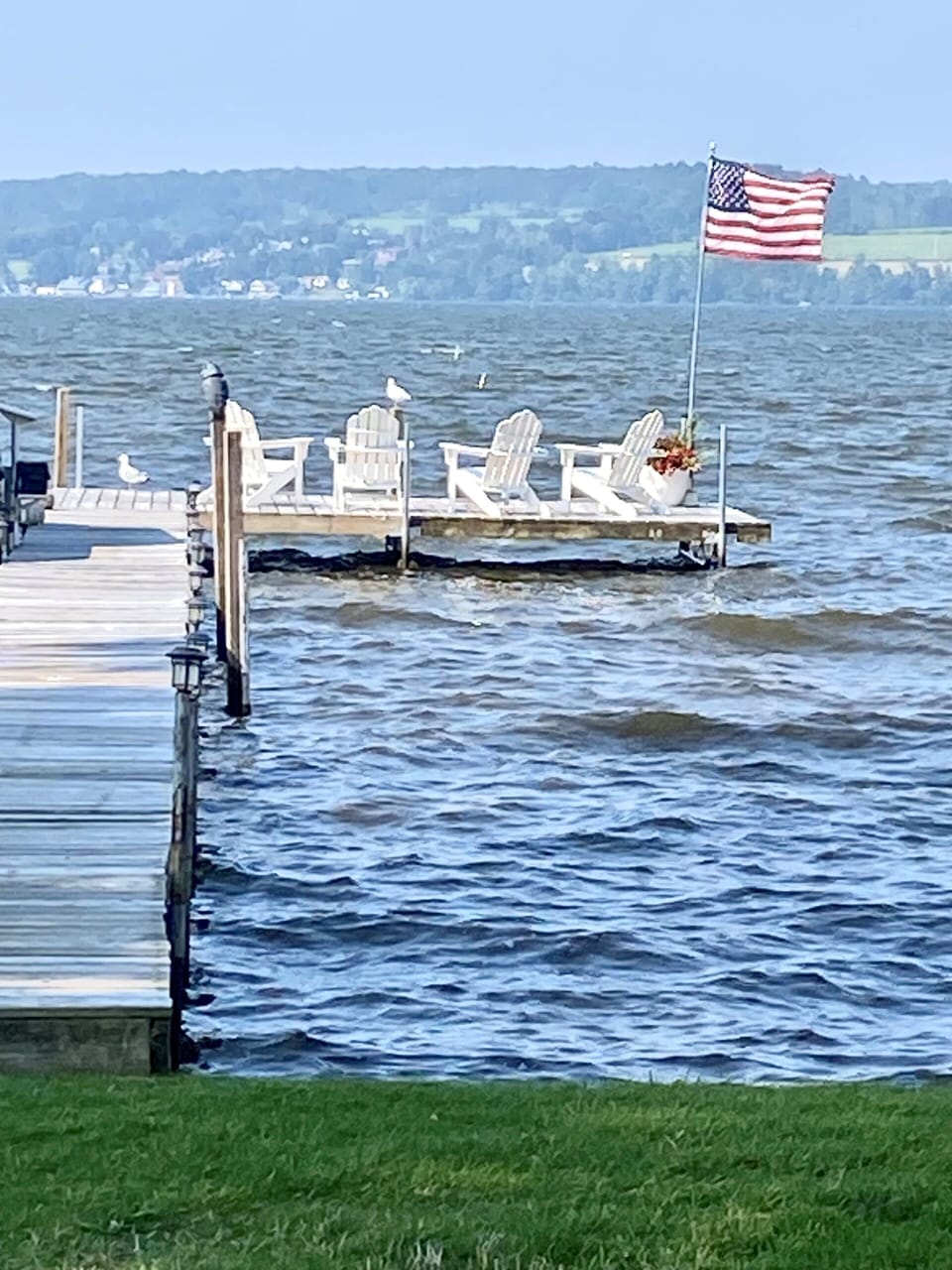 Private 100-foot dock with Adirondack chairs and panoramic lake views