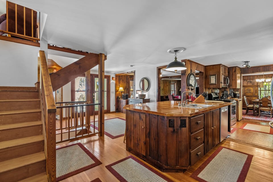Kitchen and primary stairway with living room and dining room in background