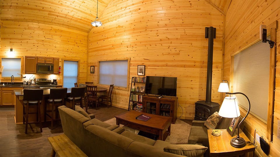 The living room, kitchen and dining areas sit beneath a beautiful pine interior.