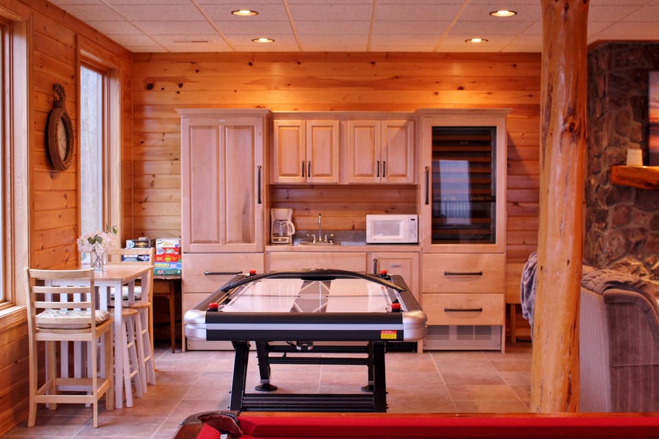 Downstairs gathering room with air hockey table, luxury bar area and dining