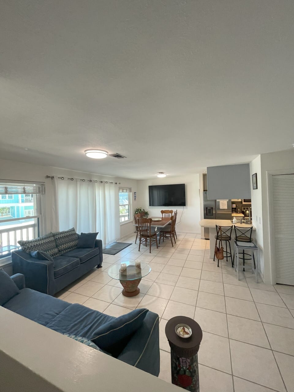 Living rm/dining rm and edge of kitchen with counter top chairs from front door