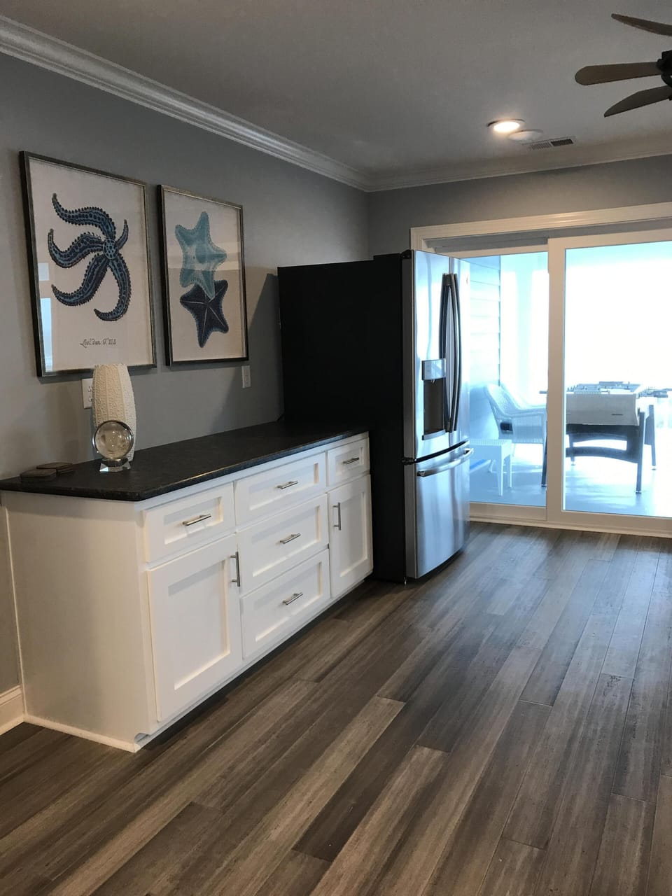 Upstair media room with refrigerator looking out on upstairs covered deck 