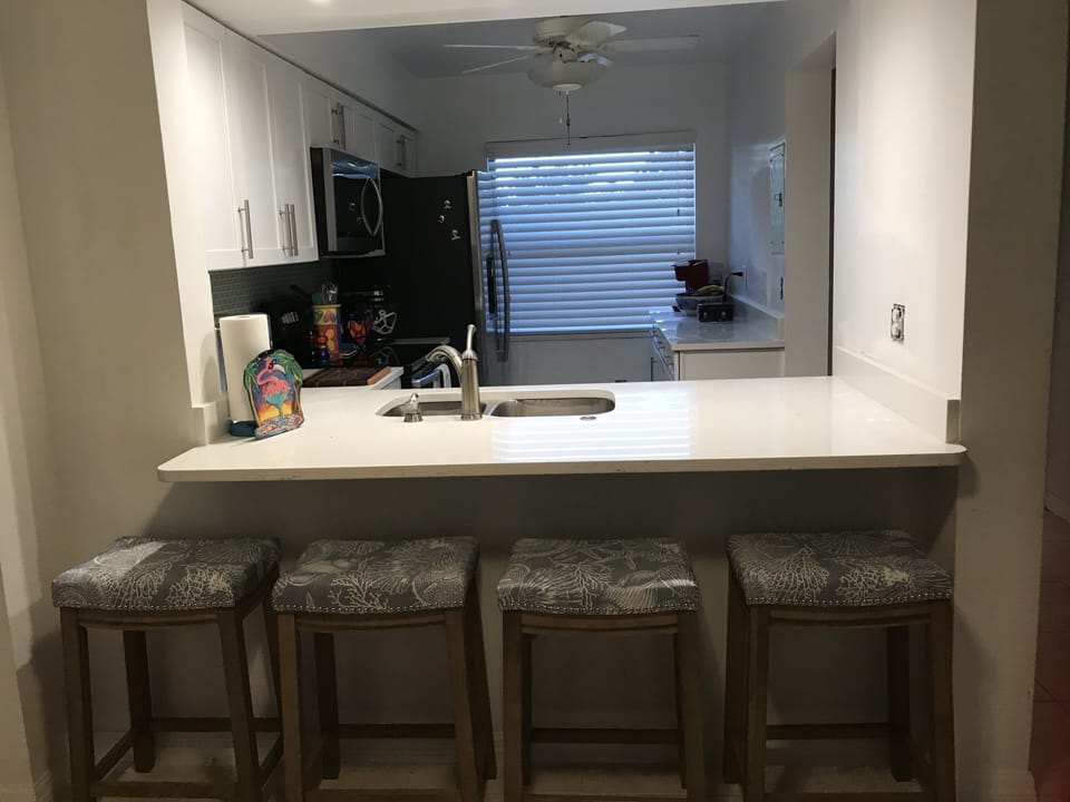 Kitchen with stools to sit and enjoy a quick meal.
