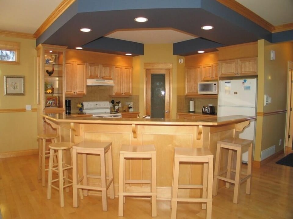 Breakfast bar seats five.  Walk-in pantry in background.