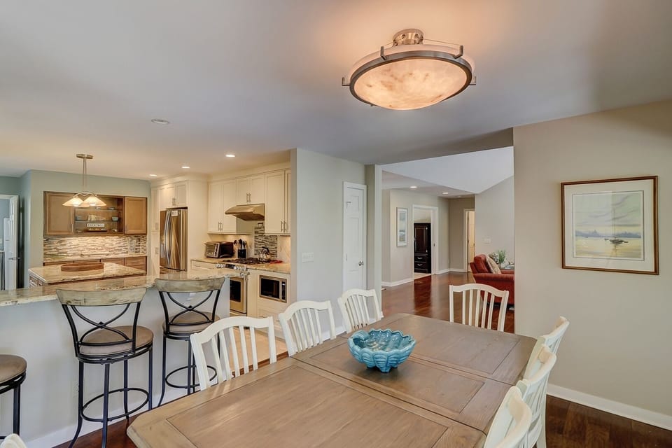 View of kitchen and great room/entryway from dining table