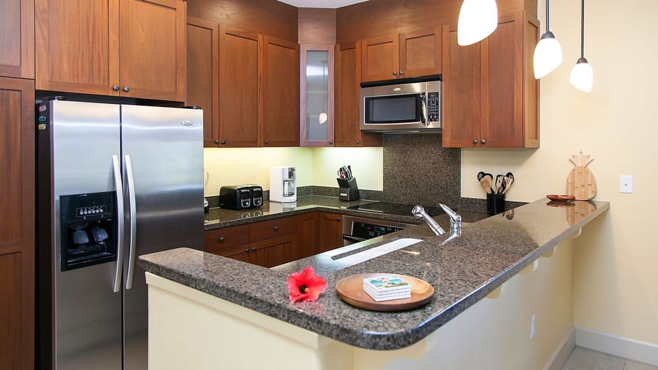Fully equipped kitchen with granite counters, stainless steel appliances.