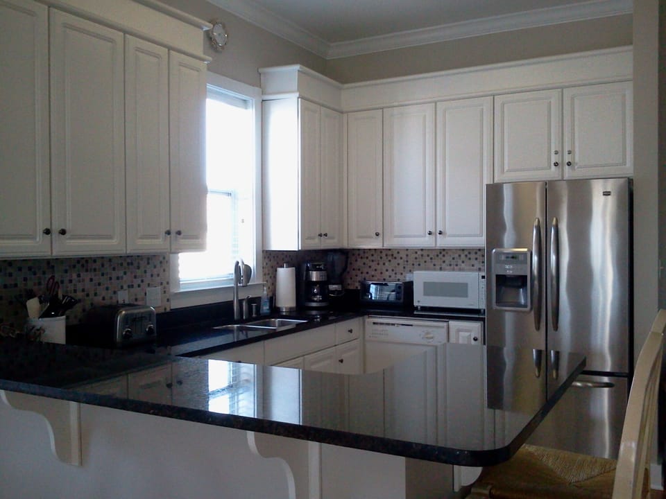 Kitchen work station, granite breakfast bar, new stainless steel refrigerator.