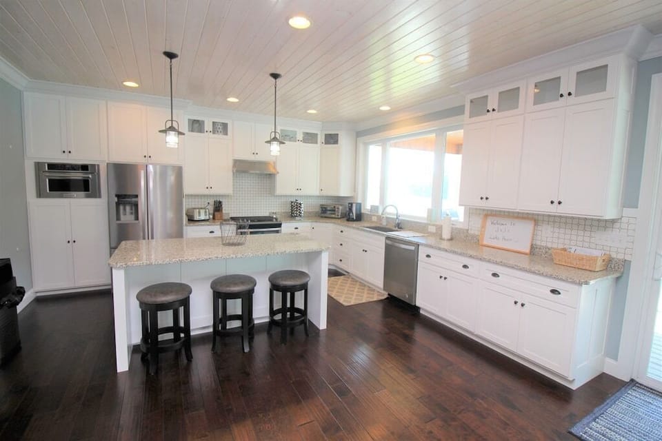 Modern kitchen overlooking the dining room, living room, and the lake.