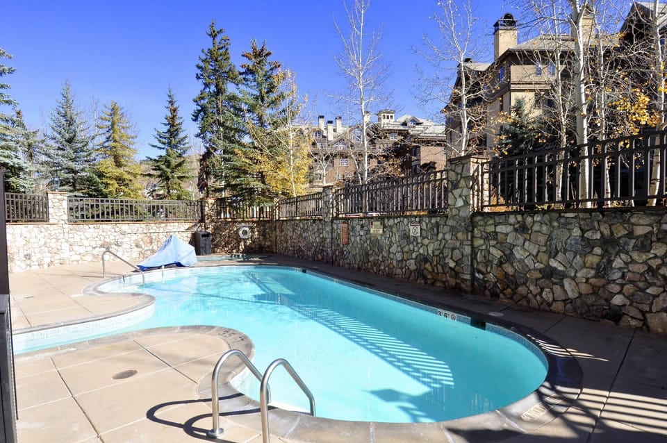 outdoor pool with hot tub in the corner