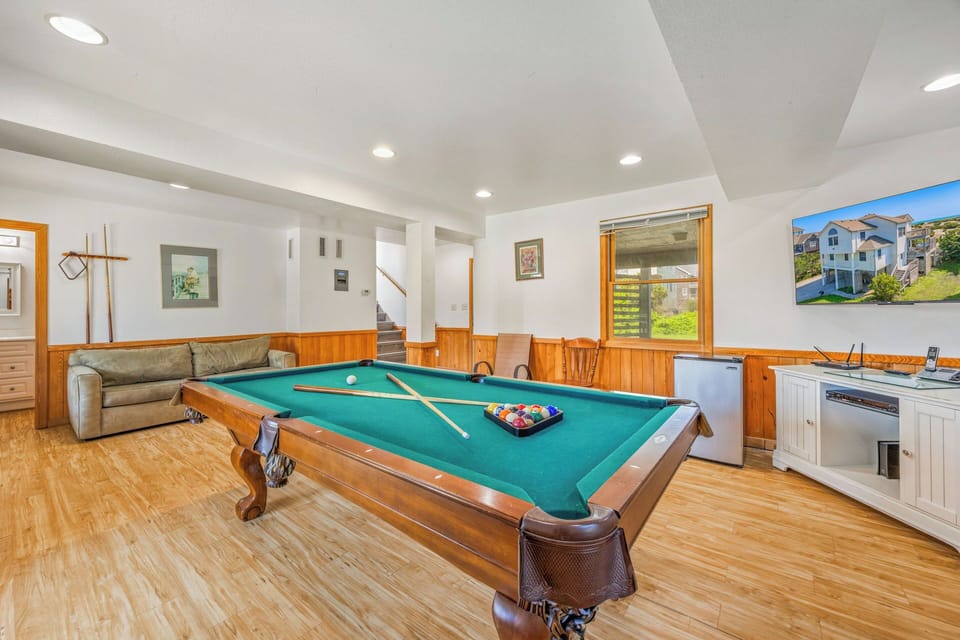 Challenge friends and family to a friendly game at your own full-sized billiards table in this spacious, naturally lit recreation room with comfortable lounge seating nearby.