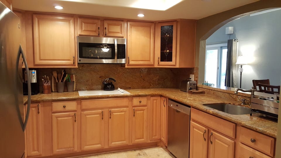 Kitchen with all extra appliances: toaster, blender, crock pot, service for 8+.