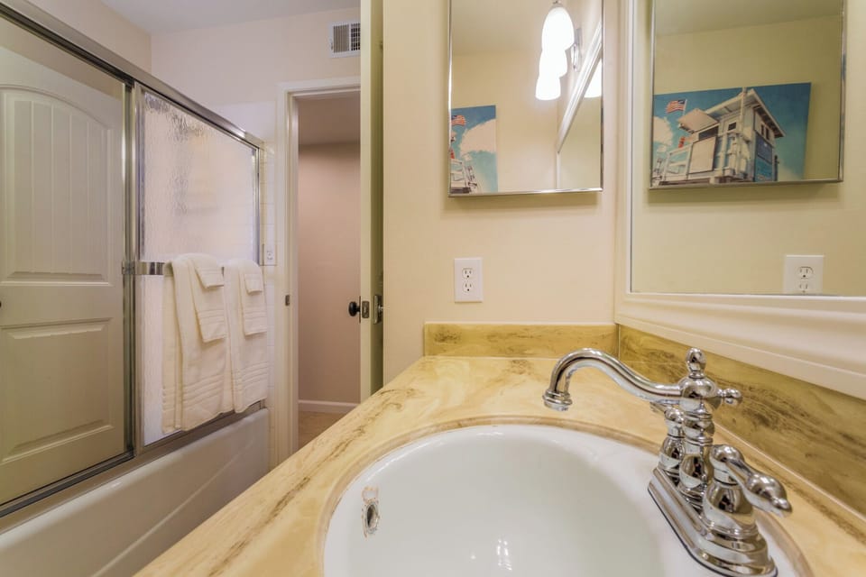 Hallway bathroom has a bathtub/shower combo.