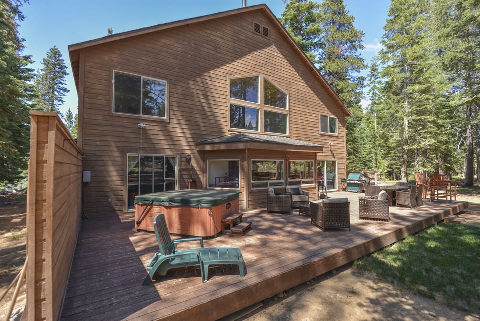 Back of the home - equipped with a hot tub, grill and outdoor furnishings