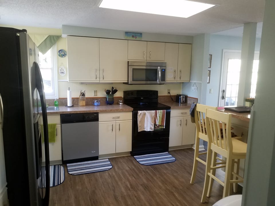 Kitchen with new flooring, Electric oven, microwave and dishwasher