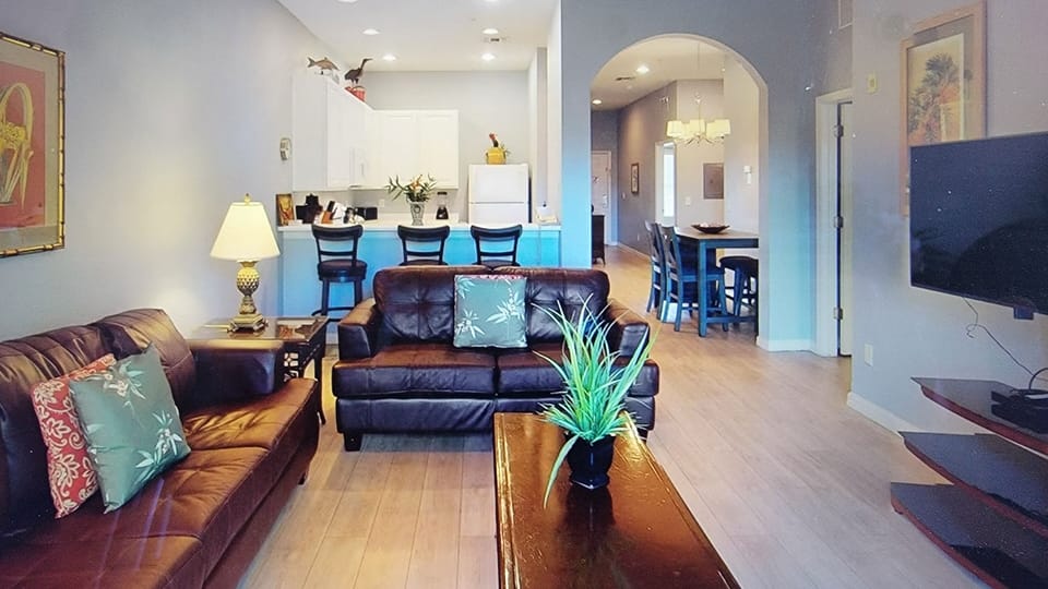 Living area, bar with 3 bar stools and kitchen
