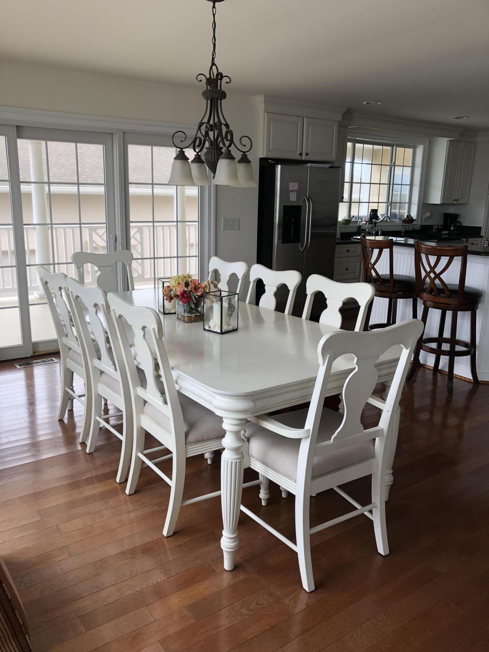 Breakfast table, bar stools and view  into roomy, well equipped kitchen.