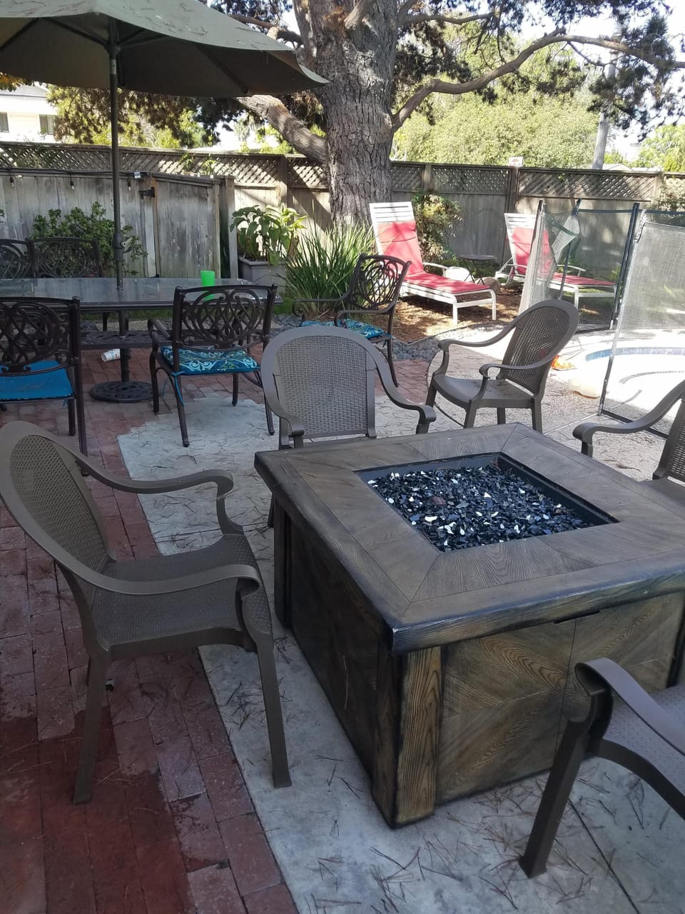 Firepit.  Off kitchen.  Pool on right. Outside dining table for 8 in back.