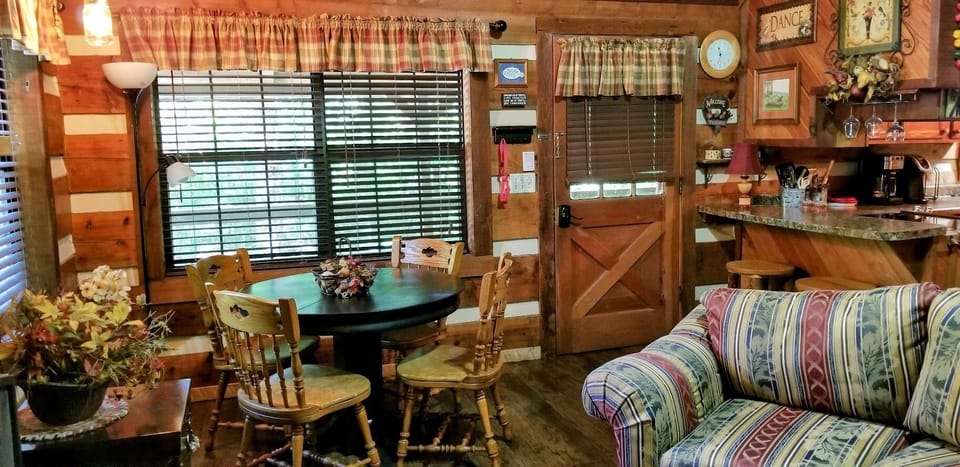 Cozy living/dining at this charming 
log cabin has table/4chairs & bar/2stools