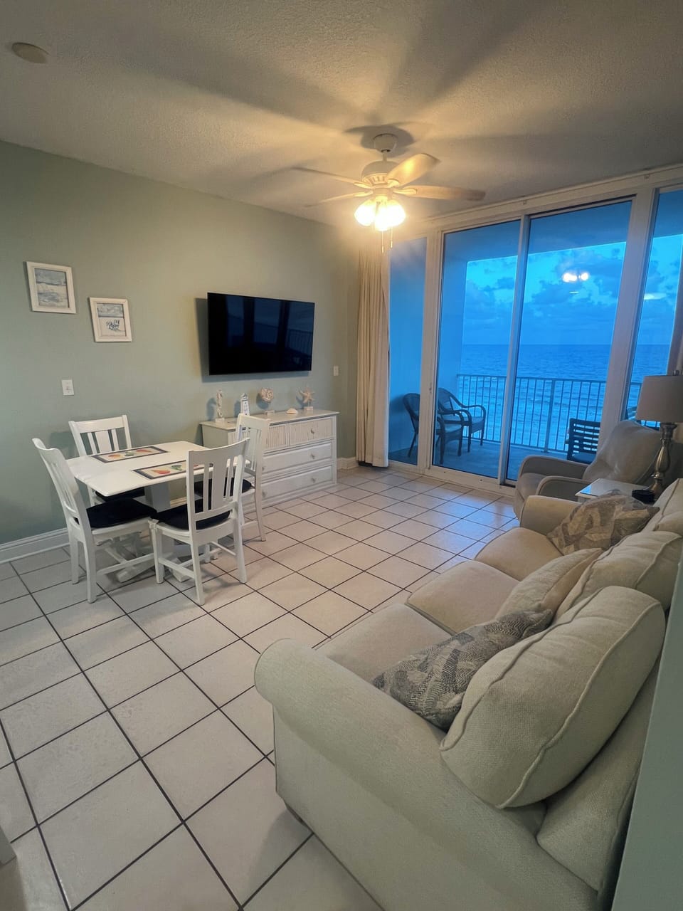 Living room, with dining table and chairs with view of the Ocean and balcony.