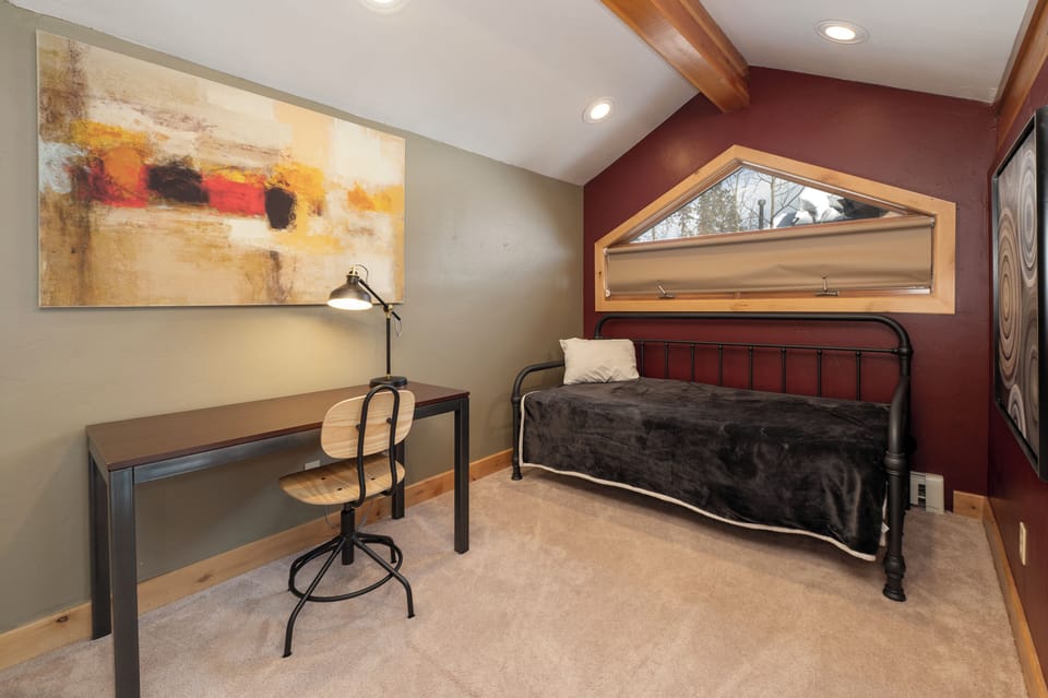 Settle into your cozy room featuring warm wood accents, modern artwork, and a dedicated workspace perfect for both rest and productivity.