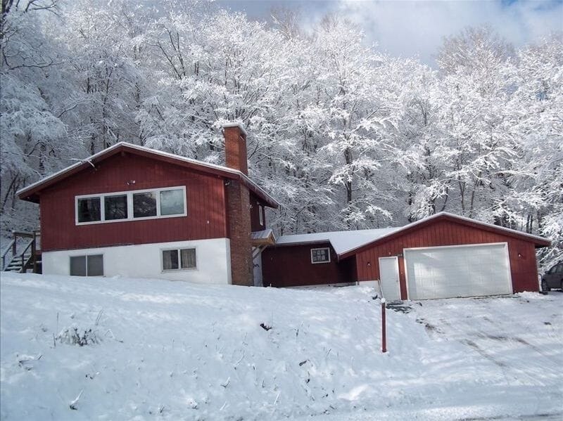 Exterior w/ 2-car garage, additional parking alongside garage