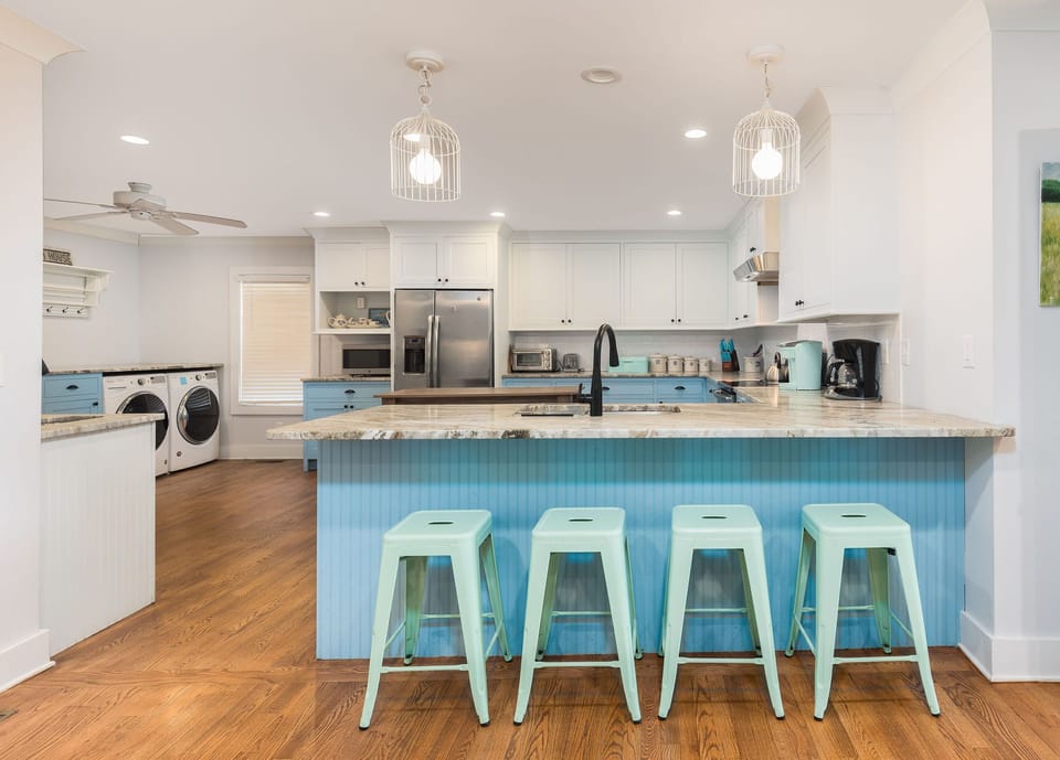 Fully equipped kitchen with stainless steel appliances and a spacious island with bar seating for casual meals or happy hour