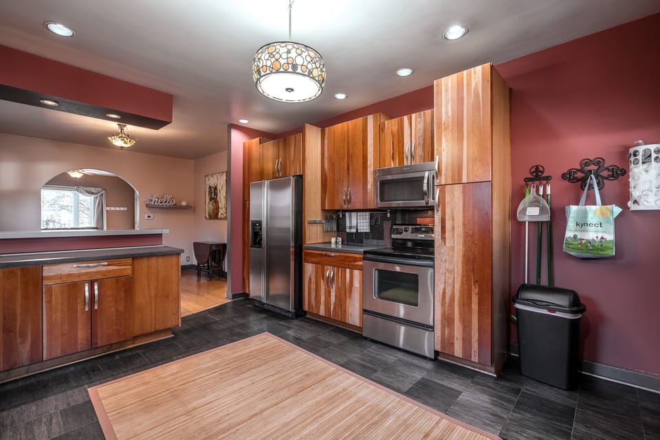 Large kitchen with large refrigerator with ice maker.