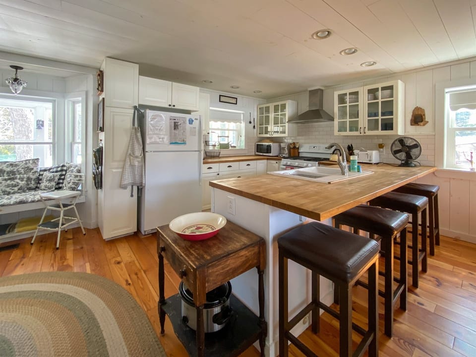 Full chef's kitchen with bar seating area. This is the breathing heart of the house, you turn around and there's the view over the lake.