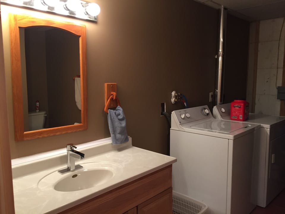 bathroom in basement with shower and washer and dryer. 