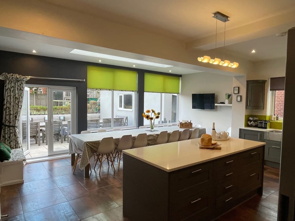 Dining table (for 18) & TV in kitchen with doors leading out to the patio