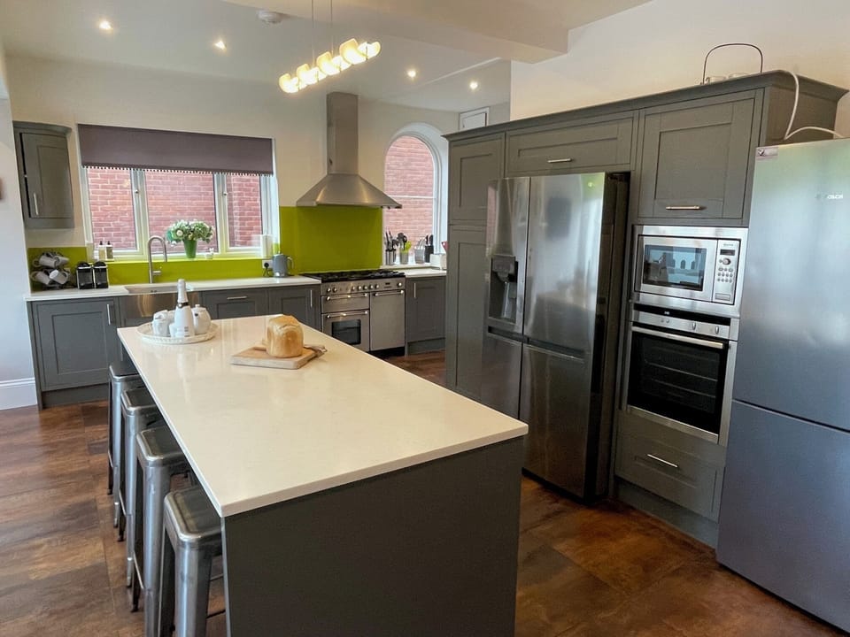 Kitchen with island seating, 2 ovens, 3 fridges, freezer,  microwave & Nespresso