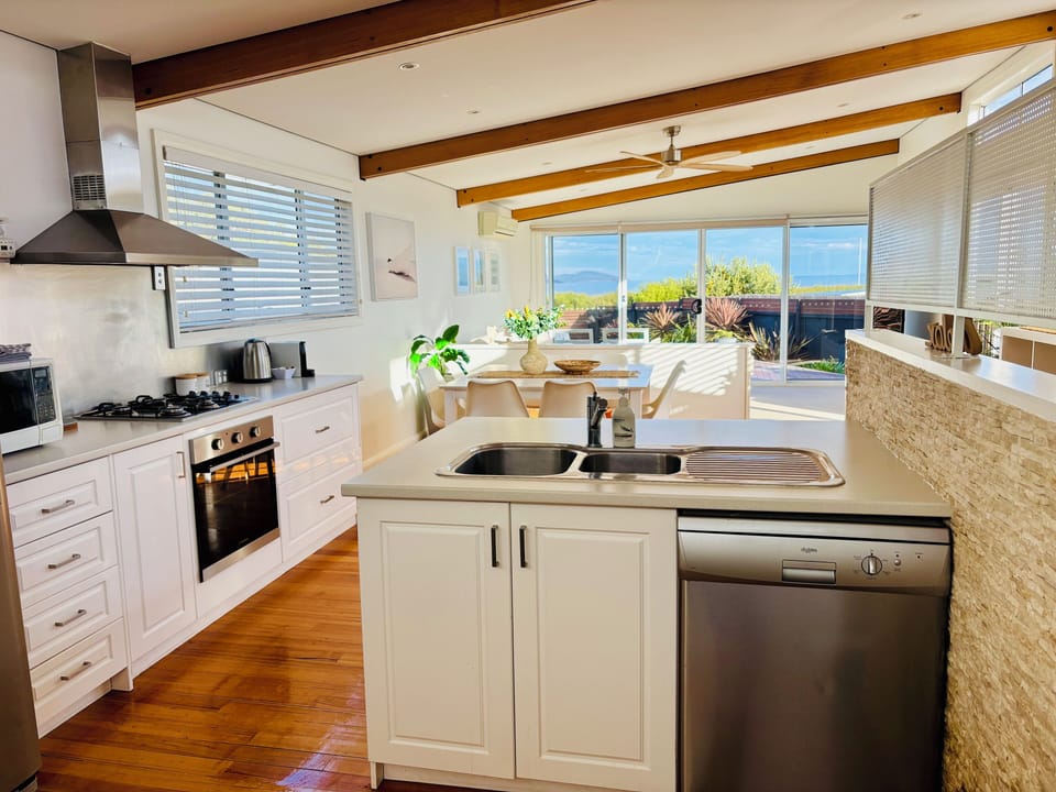 Open plan kitchen, siding, living opening onto decks